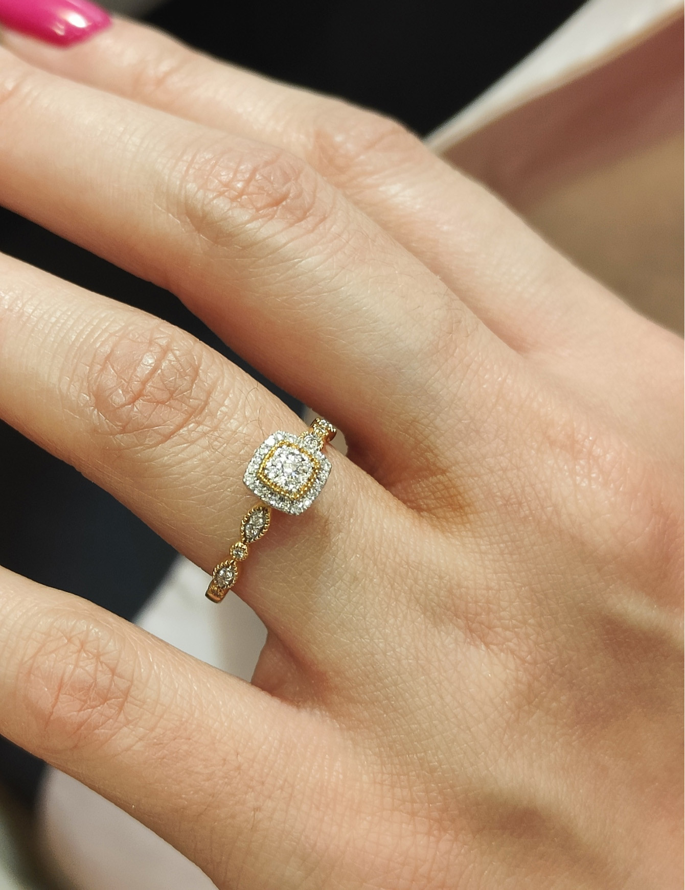 mano de una mujer con anillo de compromiso de diamantes con engaste pave